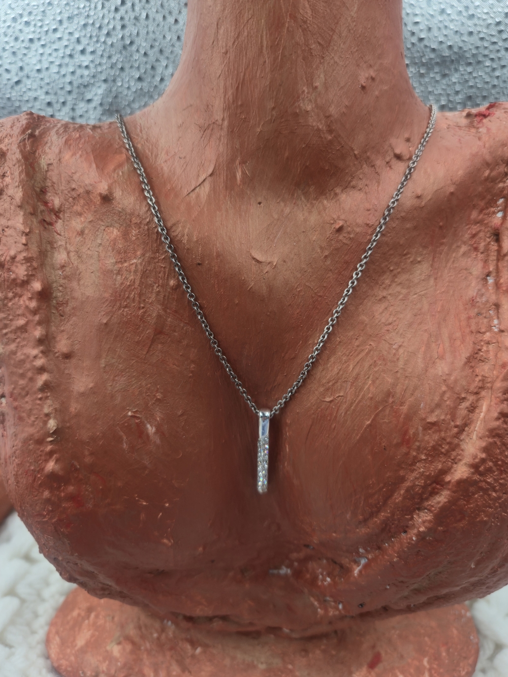 Nine West necklace features a dainty bar pendant adorned with pavé stones